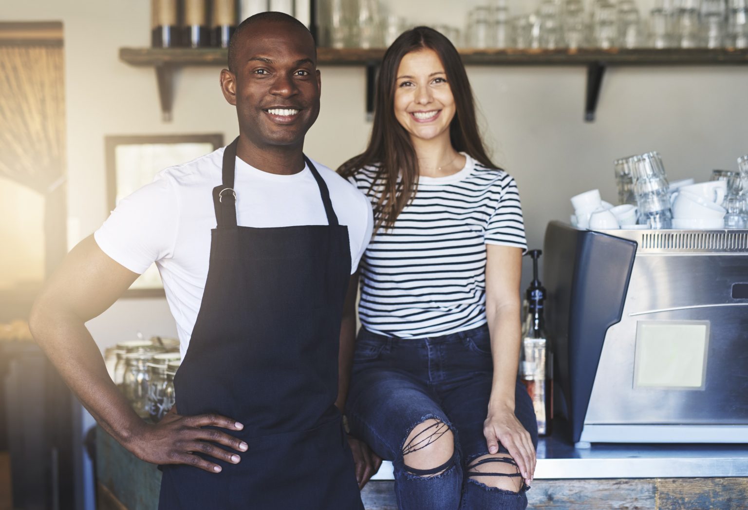 Two hospitality employees sit in a cafe by the counter